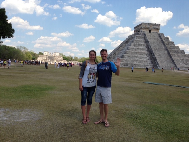 Two people in front of a pyramid in Chichen Itza